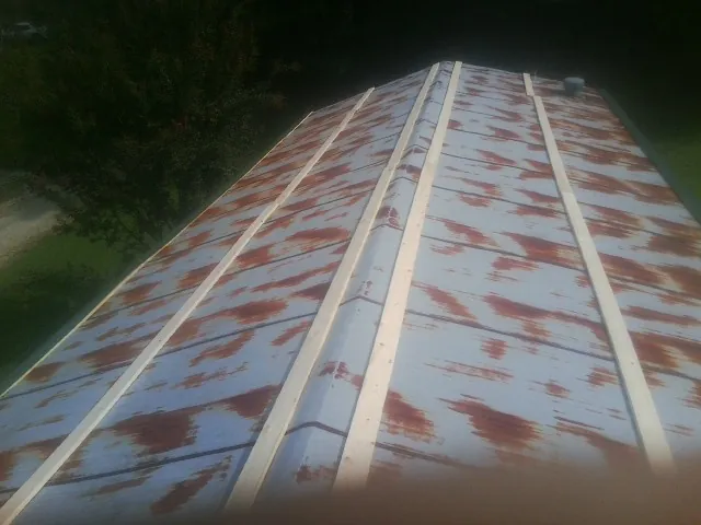 Rusted metal roof panels with new wood purlins before replacement — Storm Damage Roof Repair in Staatsburg by Roofing Brothers