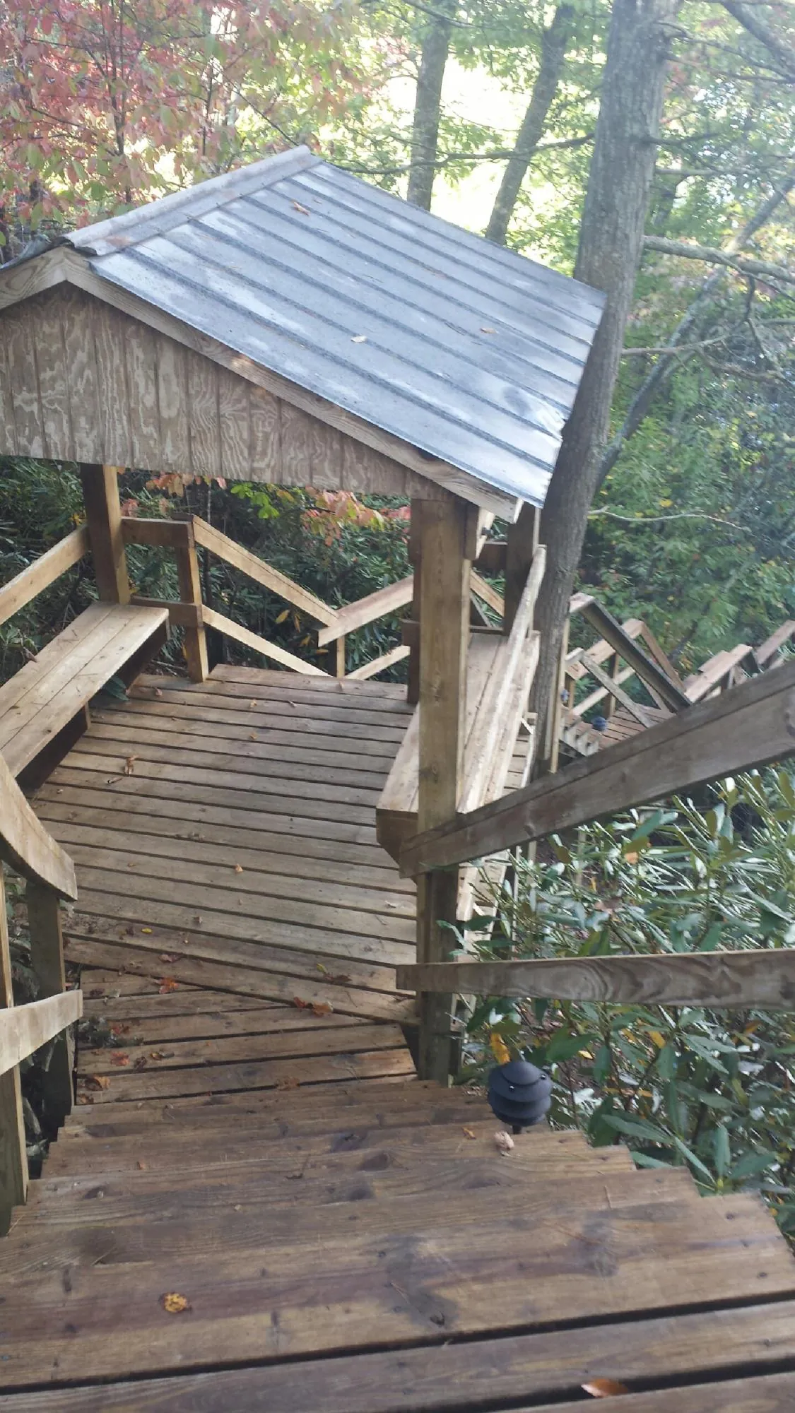 Metal roofed shelter over wooden steps on a wooded walkway — Skylight Repair & Installation work by our crew in Staatsburg