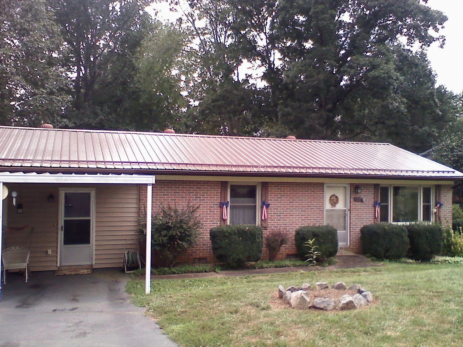 Bronze metal roof and carport on a brick ranch home — Roof Repair work by our crew in Staatsburg